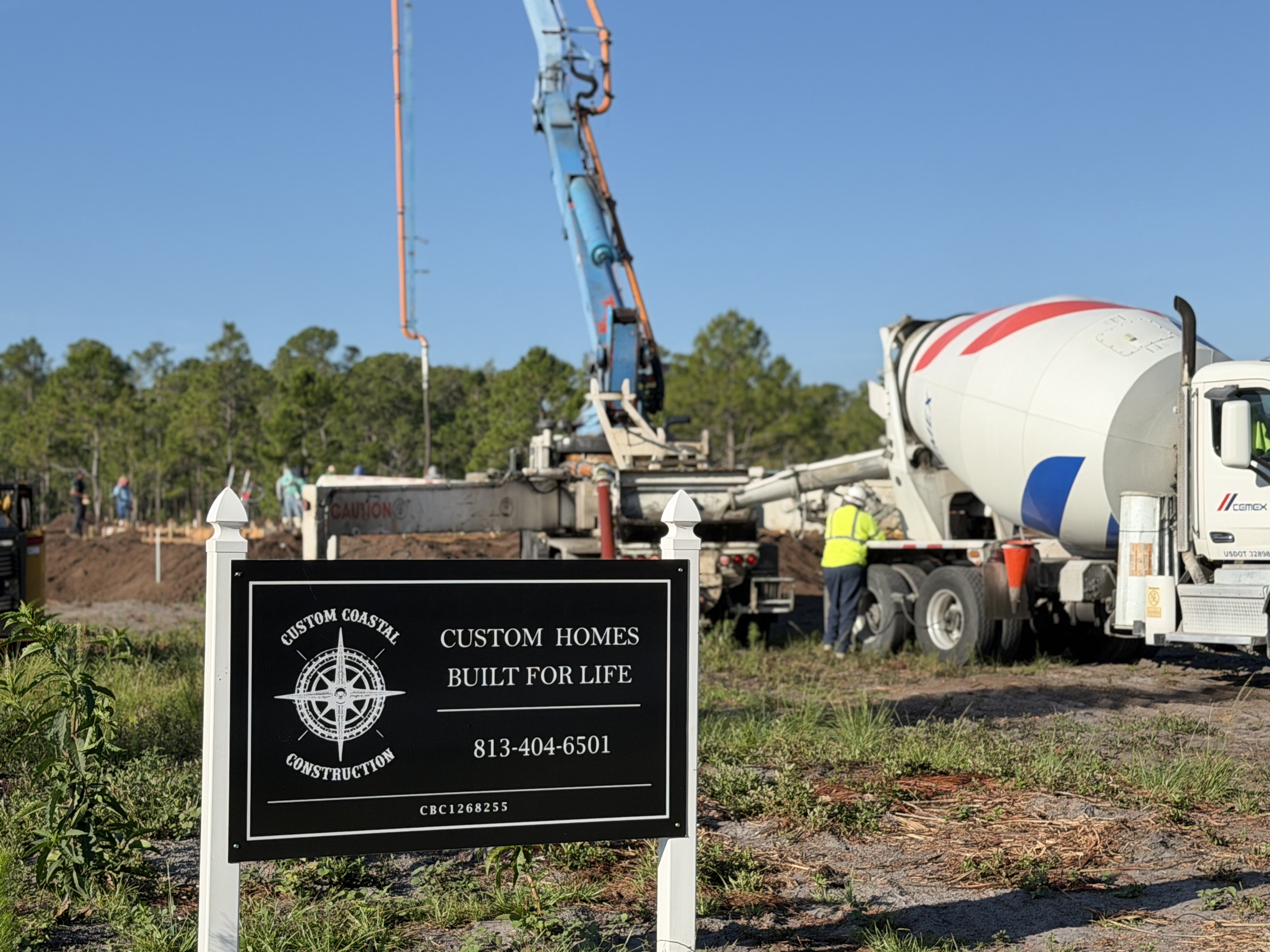 Custom Coastal Construction jobsite sign with concrete placement in Florida